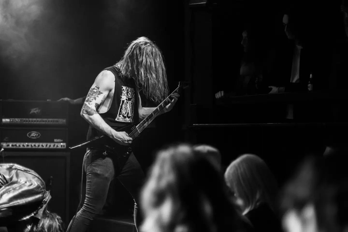 Metal musician performing live under stage lighting